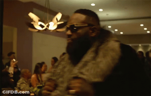 Man In Sunglasses And Fur Coat Before Crowd GIF
