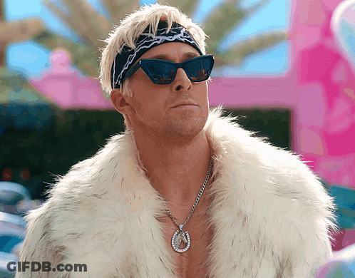 Man In Sunglasses And Fur Coat In Front Of Pink Building GIF