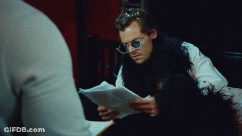Man In Sunglasses And Fur Coat Looking At Paper GIF