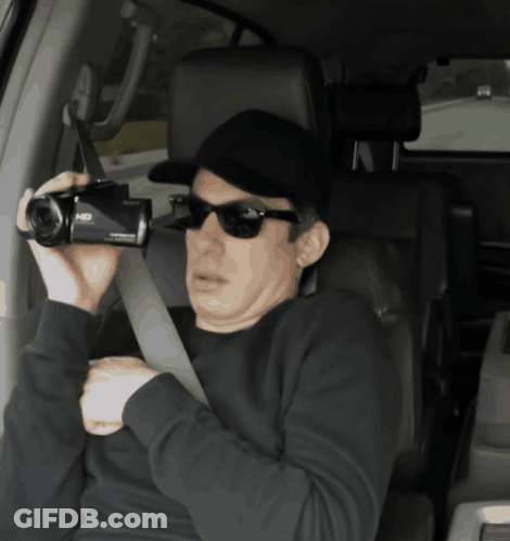 Man In Sunglasses And Hat Holding HD Camera GIF