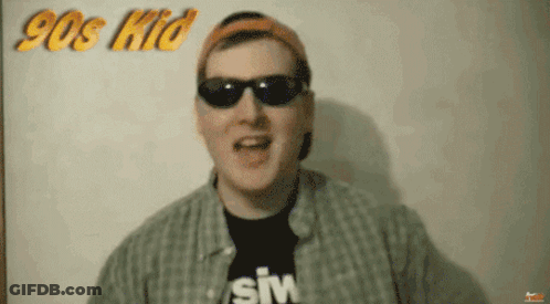 Man In Sunglasses And Hat In Front Of 90S Kid Sign GIF