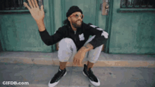 Man In Sunglasses And Hat Sitting Outside Green Door GIF