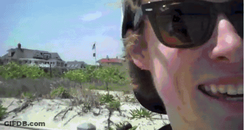Man In Sunglasses And Hat Smiling Near House GIF