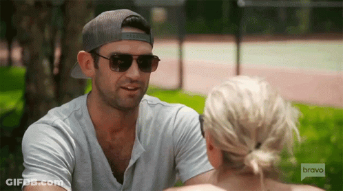 Man In Sunglasses And Hat Talking To Woman On Bravo GIF