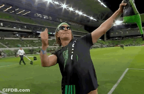 Man In Sunglasses And Headband Holding Green Object On Soccer Field GIF