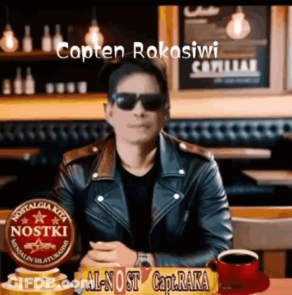 Man In Sunglasses And Leather Jacket At Table With Sign Capten Rakasiwi GIF