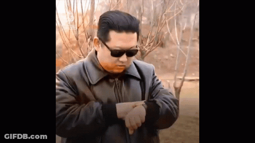 Man In Sunglasses And Leather Jacket Pointing At Watch GIF
