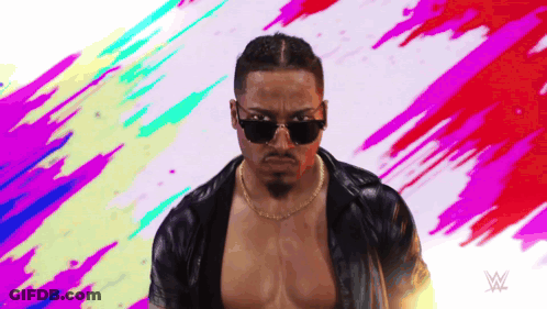 Man In Sunglasses And Necklace Before Wrestling Logo GIF