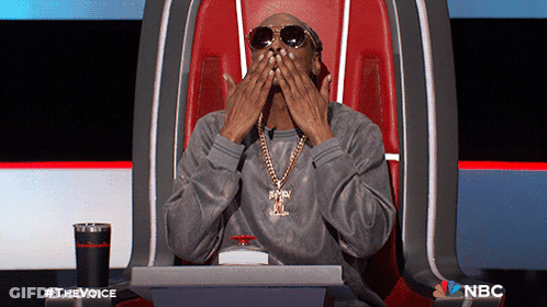 Man In Sunglasses And Necklace Sitting With NBC GIF