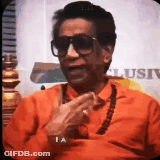 Man In Sunglasses And Orange Shirt Talking On Phone GIF