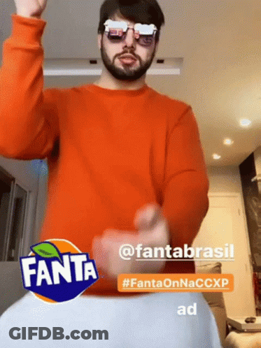 Man In Sunglasses And Orange Sweater Dancing In Front Of Fanta Sign GIF