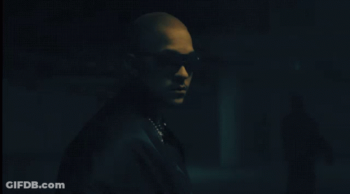 Man In Sunglasses And Pearl Necklace In Dark Room GIF