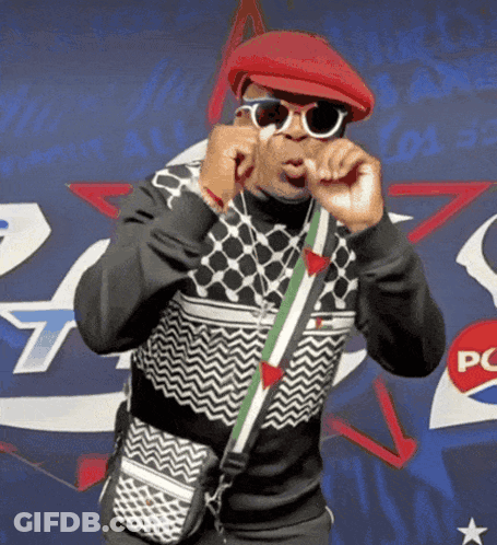 Man In Sunglasses And Red Hat In Front Of Pepsi Sign GIF