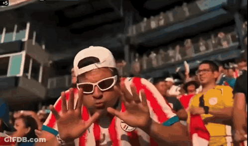 Man In Sunglasses And Red Striped Shirt In Crowd GIF