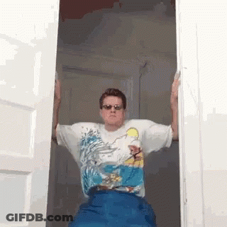 Man In Sunglasses And Simpson Shirt Standing In Open Doorway GIF