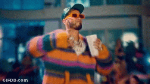 Man In Sunglasses And Striped Jacket Holding Coffee On Stage GIF