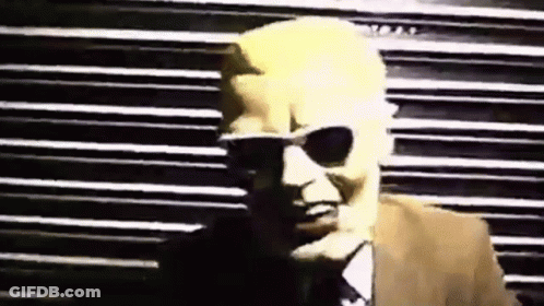 Man In Sunglasses And Suit By Striped Wall GIF