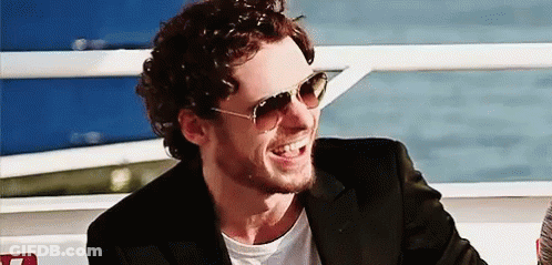 Man In Sunglasses And Suit Smiling On Boat GIF
