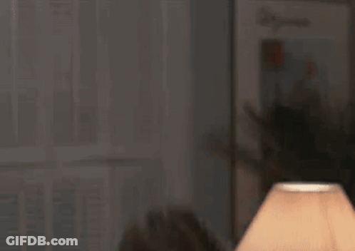 Man In Sunglasses And Suit Smiling On Couch GIF