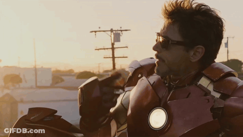 Man In Sunglasses And Superhero Suit Looking To Side GIF