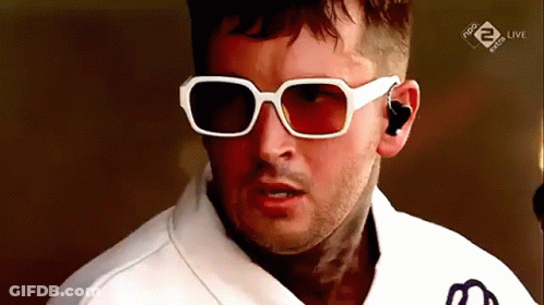 Man In Sunglasses And White Shirt Looking At Camera GIF