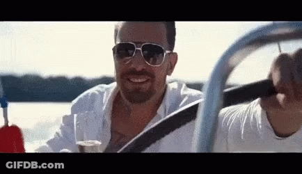 Man In Sunglasses Driving Boat Holding Wine GIF