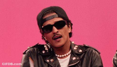 Man In Sunglasses Hat And Leather Jacket Holding Two Flags GIF