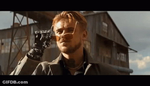 Man In Sunglasses Holding Camera In Front Of Building GIF