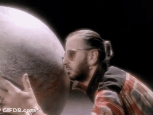Man In Sunglasses Holding Globe In Dark Room GIF