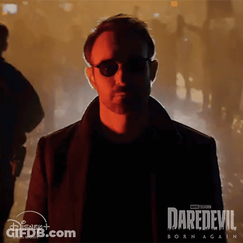 Man In Sunglasses In Front Of Daredevil Born Again Poster GIF