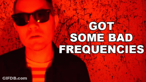 Man In Sunglasses In Front Of Red Wall Saying Got Some Bad Frequencies GIF