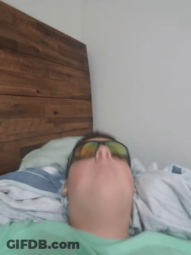 Man In Sunglasses Lying On Bed Eyes Closed GIF