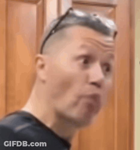 Man In Sunglasses Making Funny Face In Front Of Wooden Cabinet GIF
