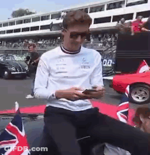 Man In Sunglasses On Car Looking At Phone GIF