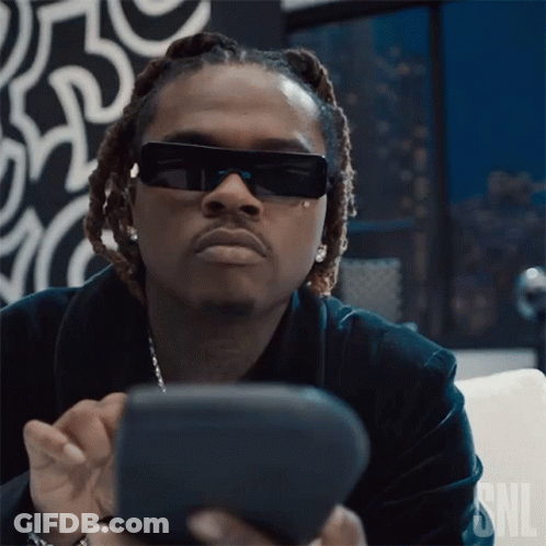 Man In Sunglasses Sitting On Couch Looking At Phone GIF