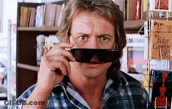 Man In Sunglasses Standing In Front Of Edge Sign GIF