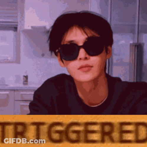 Man In Sunglasses Standing In Front Of Yellow Triggered Sign GIF