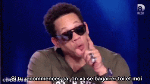 Man In Sunglasses Talking Into Microphone Says Si Tu Recommences GIF
