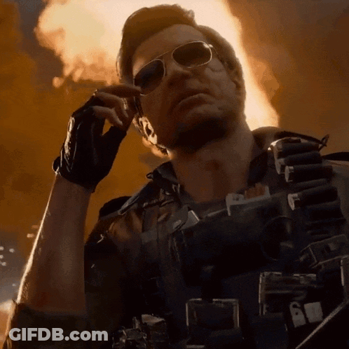 Man In Sunglasses Talking On Cell Phone In Front Of Fire GIF