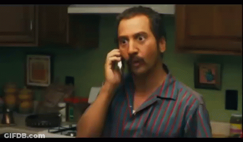 Man In Sunglasses Talking On Cell Phone In Kitchen GIF