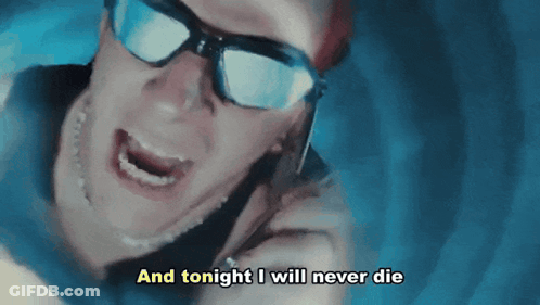 Man In Sunglasses Talking On Cell Phone Saying And Tonight I Will Never Die GIF