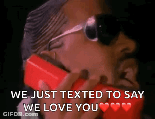 Man In Sunglasses Talking On Red Cell Phone We Just Texted To Say We Love You GIF