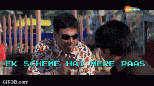Man In Sunglasses Talking With Ek Scheme Hai Mere Paas Behind Him GIF