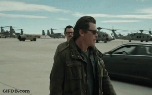 Man In Sunglasses Walking Beside Man In Glasses GIF