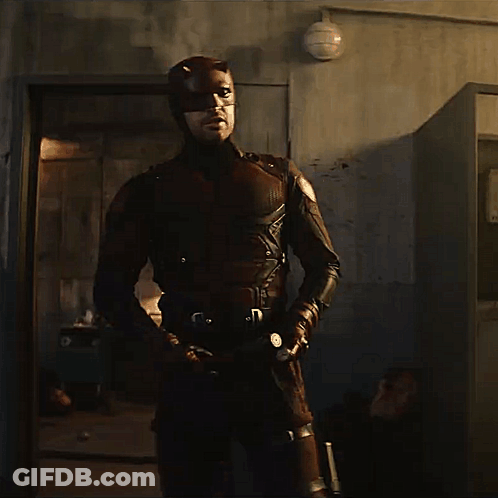 Man In Superhero Costume Holding Bat GIF
