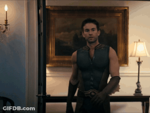 Man In Superhero Costume In Front Of Lamp GIF