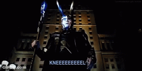 Man In Superhero Costume Kneeling In Front Of Building GIF