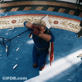 Man In Superhero Costume Kneeling On Blue Rug GIF