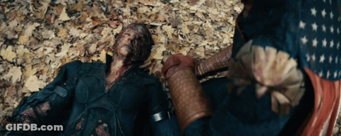 Man In Superhero Costume Laying On Ground With Leaves GIF