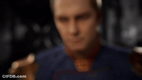 Man In Superhero Costume Looking At Bottle GIF